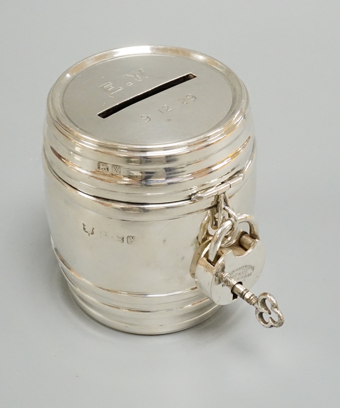 A George V silver barrel money box, with padlock & key, William Neale Ltd?, Birmingham, 1922, height 67mm.